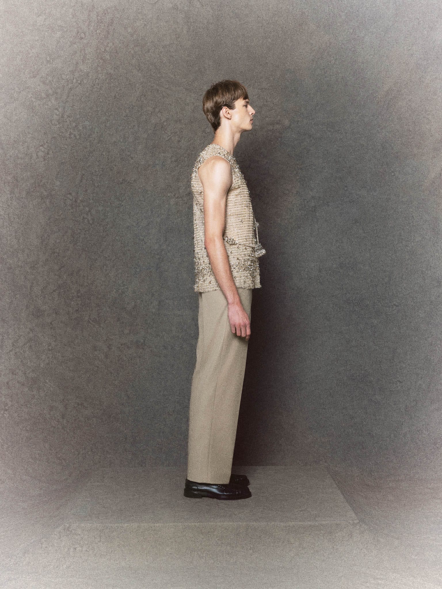 Nude mesh sleeveless top with crystal embellishments paired with gray trousers - Image 3