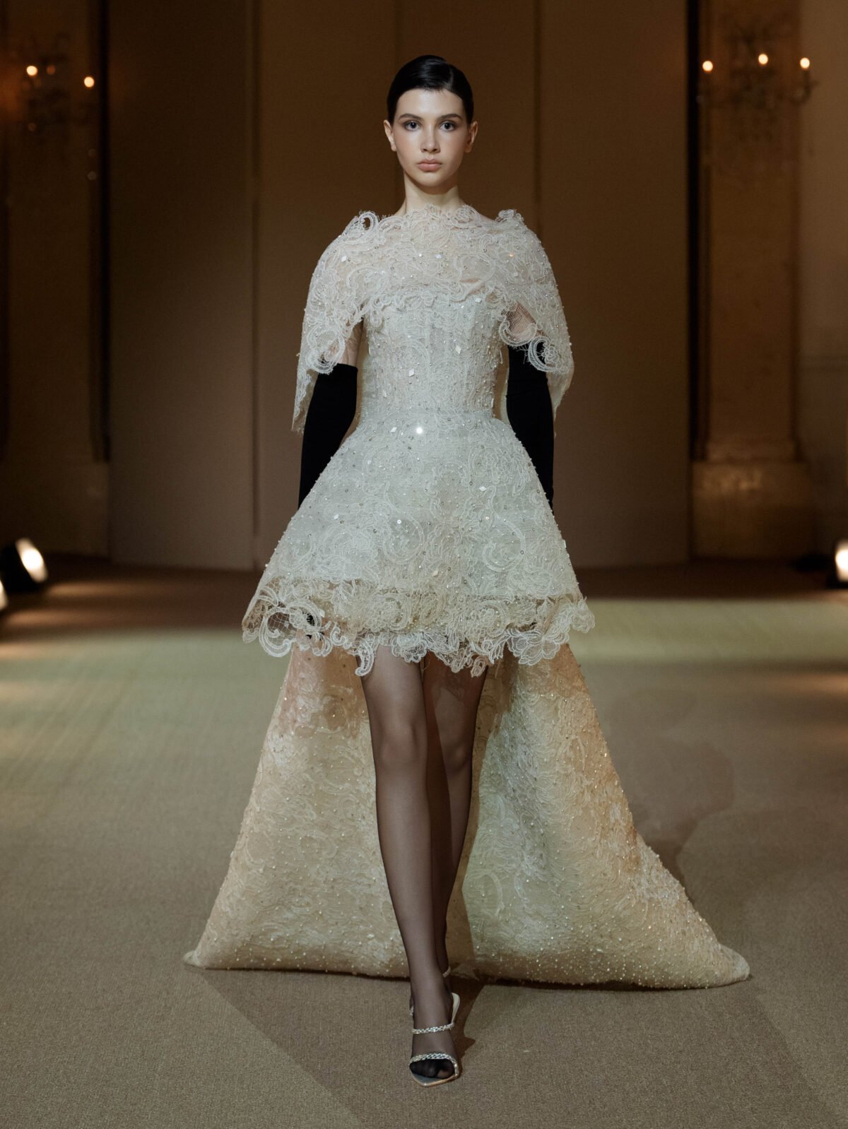Creamy white guipure lace evening ensemble with a high-low shoulder cape