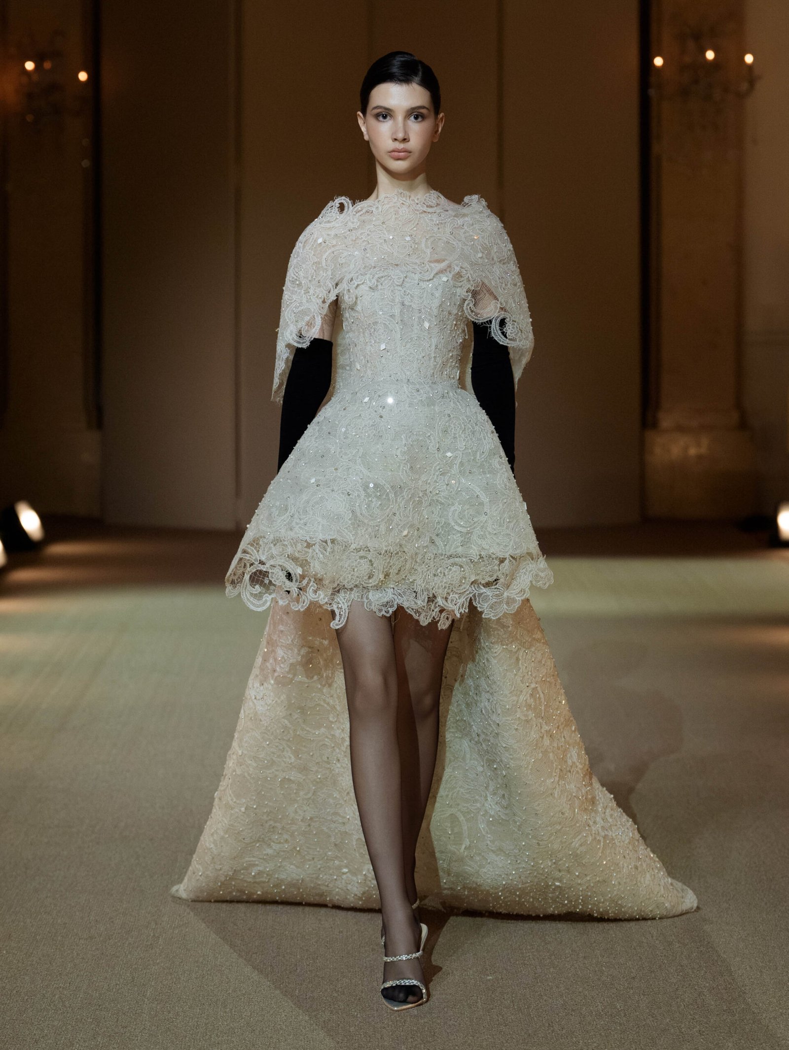 Creamy white guipure lace evening ensemble with a high-low shoulder cape