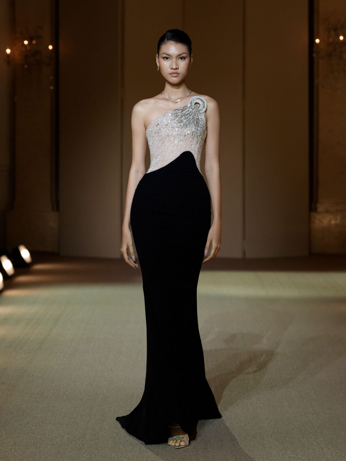 Black asymmetrical mermaid gown with a beige tulle bustier
