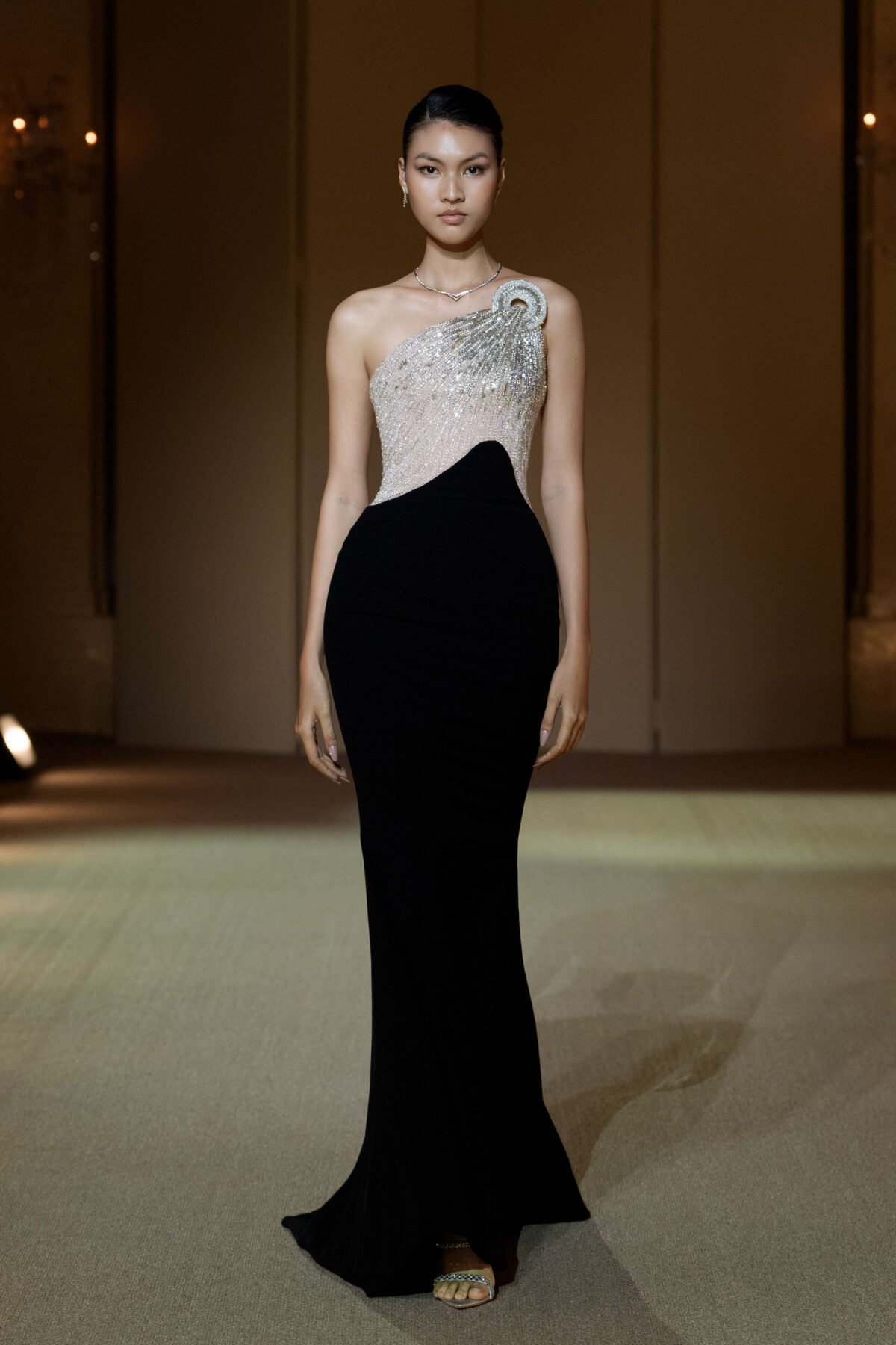 Black asymmetrical mermaid gown with a beige tulle bustier