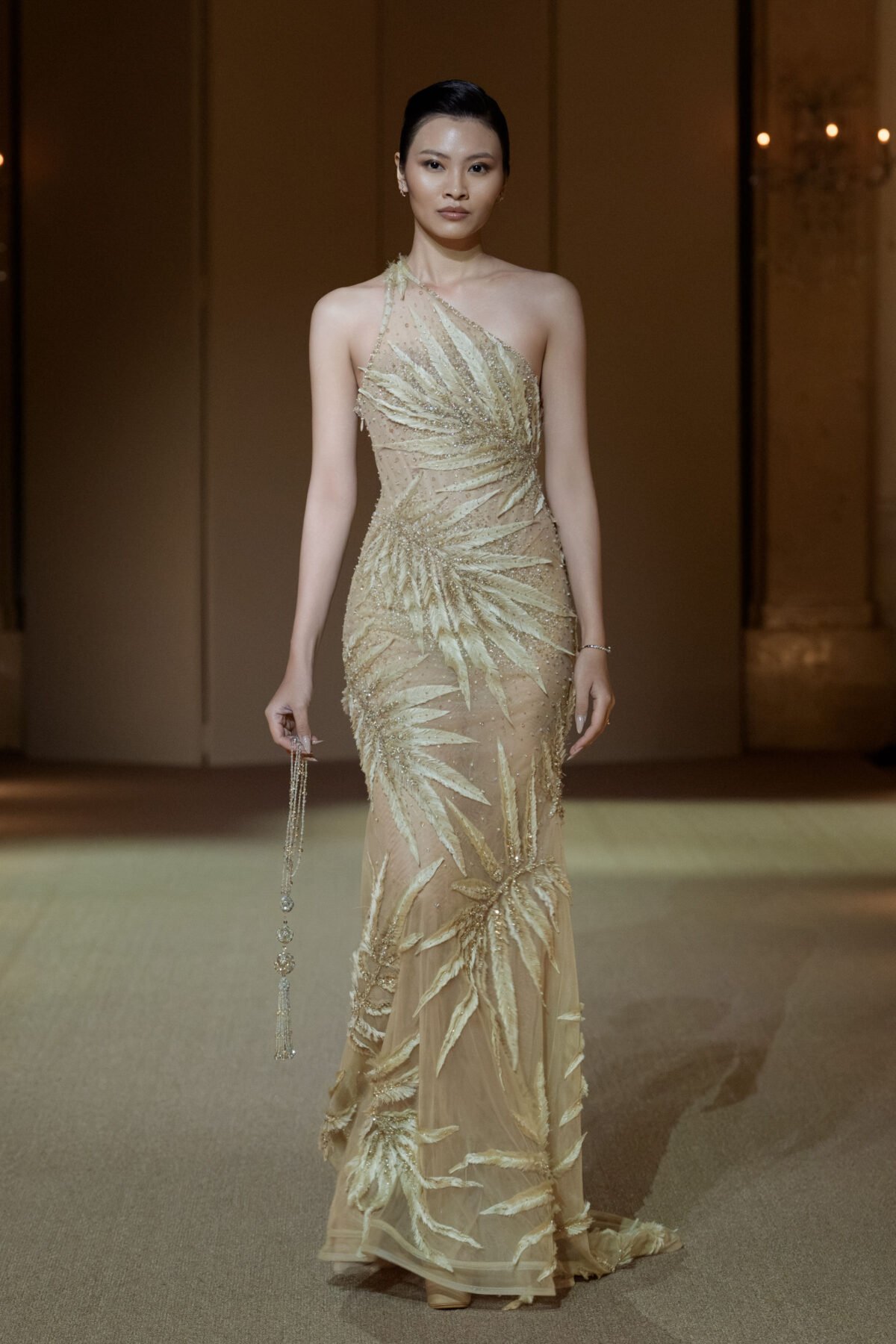 Champagne one-shoulder gown with embellished feather motifs