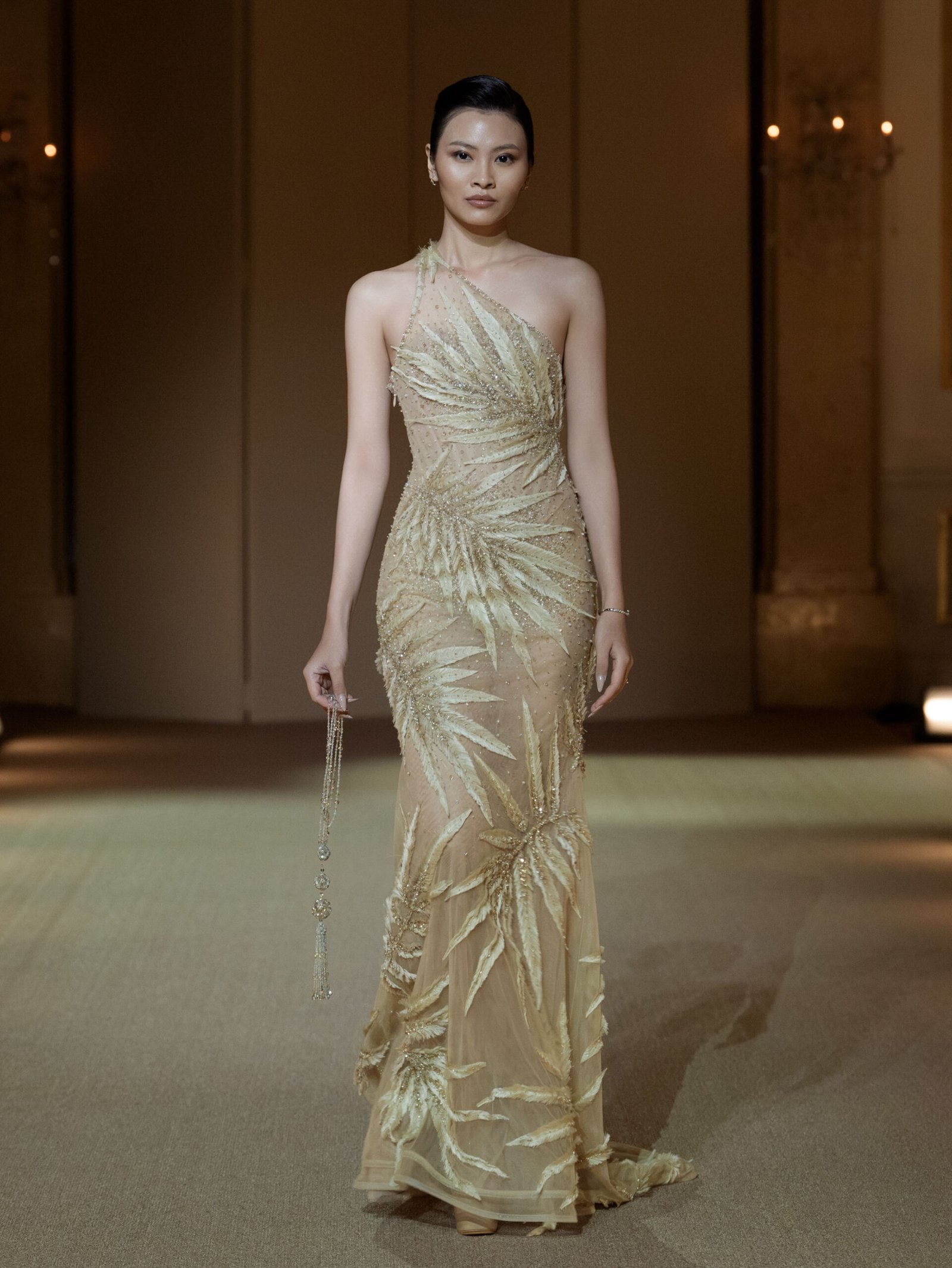 Champagne one-shoulder gown with embellished feather motifs