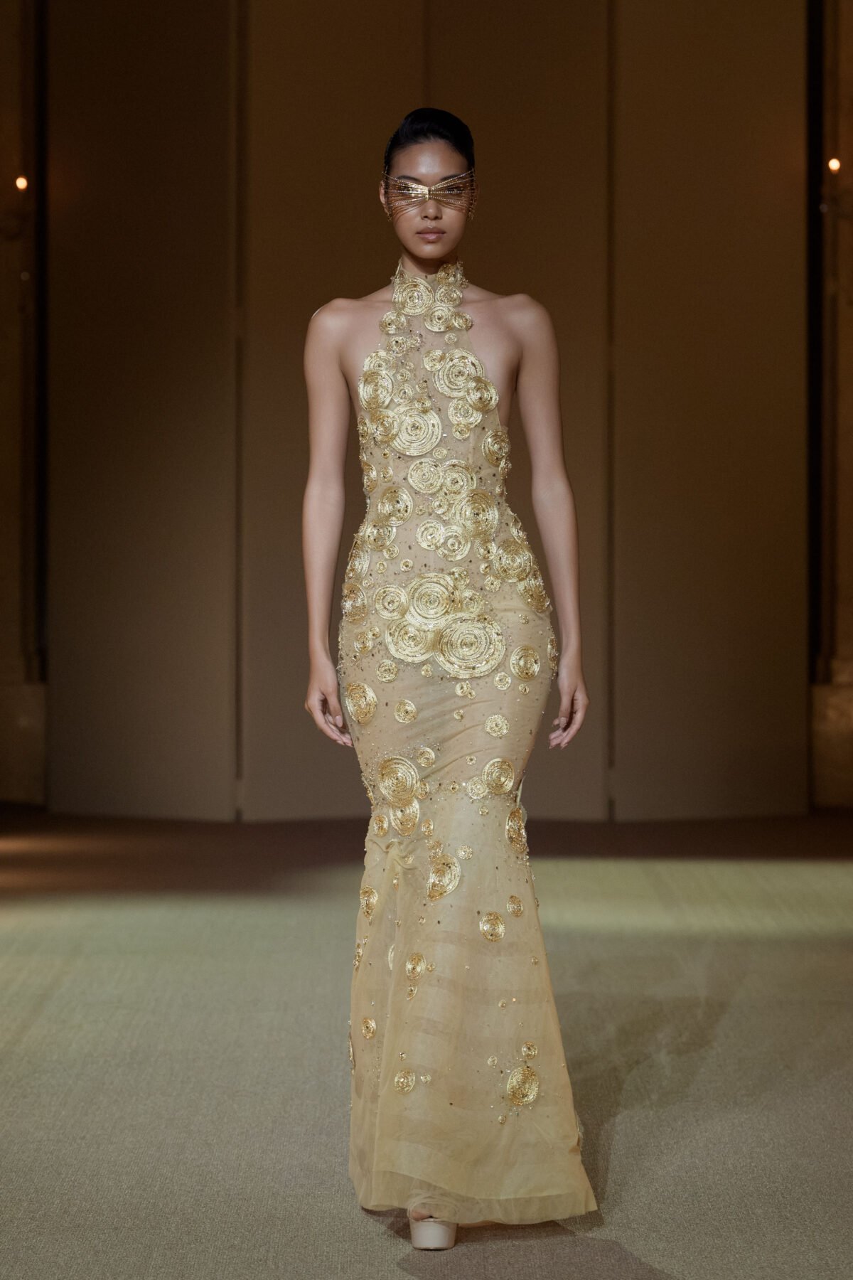 Gold halterneck mermaid gown with crystal-embellished circular discs