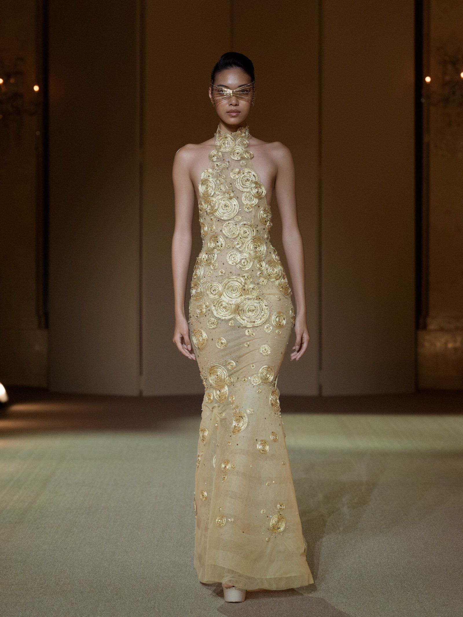 Gold halterneck mermaid gown with crystal-embellished circular discs
